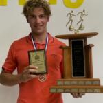 young man in red shirt holding trophy and certificate