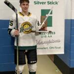 Young man in hockey jersey holding hockey stick and award