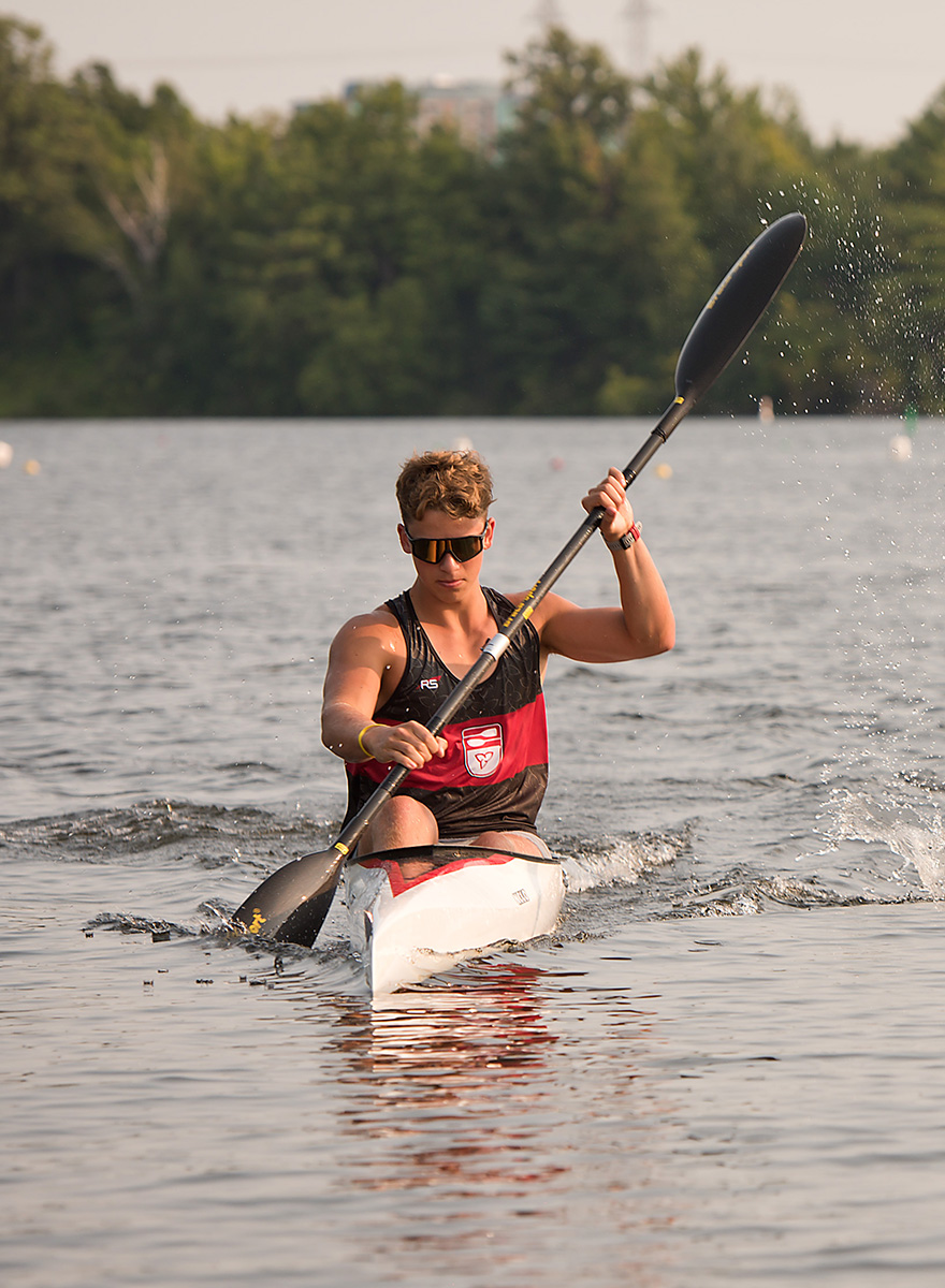 action shot of young man paddling in a kayak