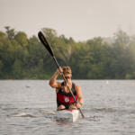 young man in kayak paddling toward us