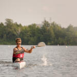 young man in kayak paddling toward us