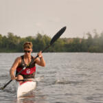 young man in kayak paddling toward us