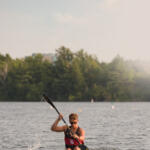 young man in kayak paddling toward us