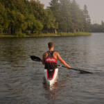 young man paddling in kayak