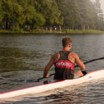 young man sitting in kayak holding paddle