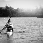 grayscale image young man in kayak paddling toward us