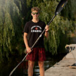 young man in black tee holding paddle