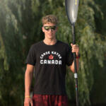 young man in black tee holding paddle