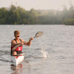 young man in kayak paddling toward us