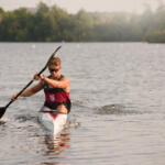 young man in kayak paddling toward us