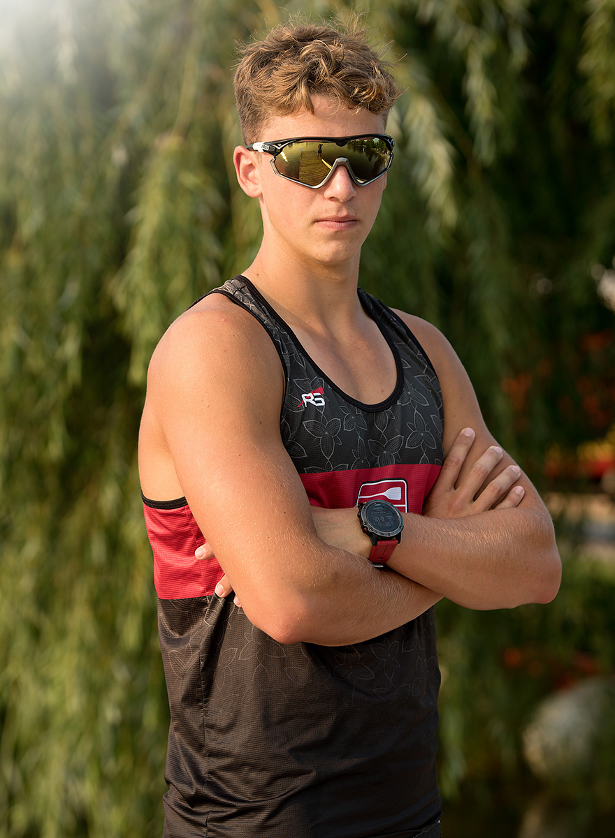 young man wearing sunglasses in tank top with arms folded