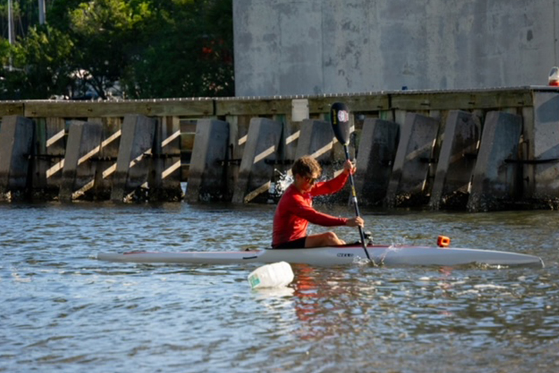 man in kayak rowing to screen right